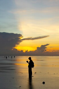 夕阳下海边的摄影者