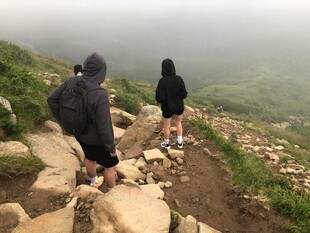 两人徒步于山间崎岖小径