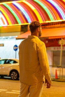 夜晚男子于彩色灯光下行走