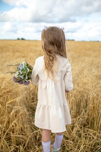 田野中持花小女孩背影