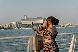 海边女子用望远镜眺望远方