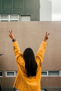 穿黄衣女子户外比耶背影