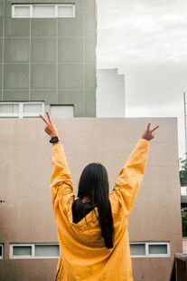 穿黄衣女子背对镜头展双臂