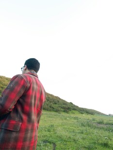 穿格子大衣男子眺望草地