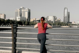 女子河畔倚栏赏景