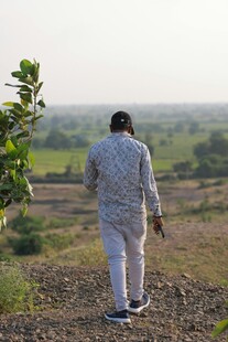 男子于田野间独行背影