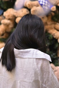 长发女子背对毛绒玩具