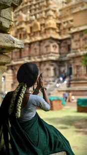 女子于古老庙宇前专注拍照