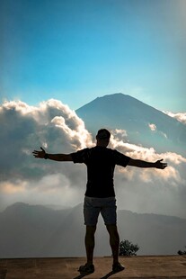 山顶男子舒展双臂迎美景