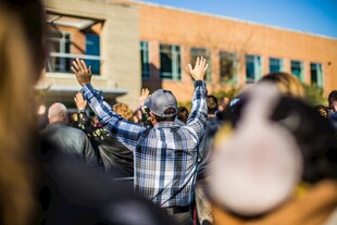 人群集会中高举双手的人