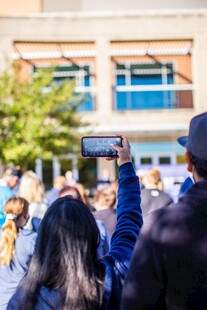 人群中举起手机拍照瞬间