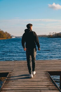 男子独行于湖畔木栈道