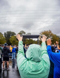 雨中人群高举双手拍照