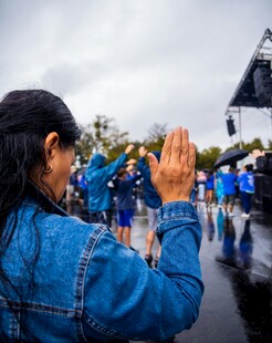 女子雨中向人群挥手