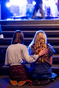 舞台前两女孩温馨依偎