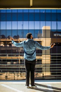 男子于高楼前舒展双臂