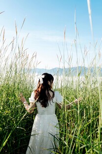 白衣女子于草丛中悠然伫立
