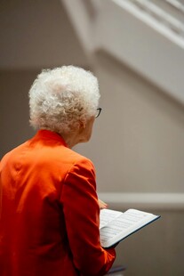 红衣老人专注阅读文件