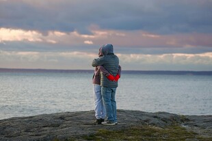 情侣海边依偎赏壮丽景色