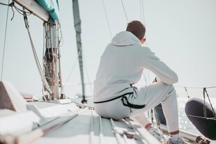 男子坐于帆船享受海上时光