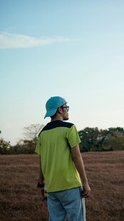 田野中戴蓝帽的少年背影