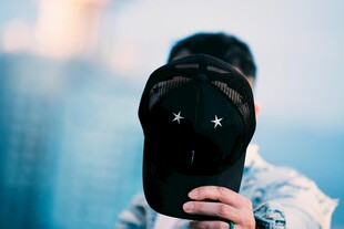 手持黑帽男子特写