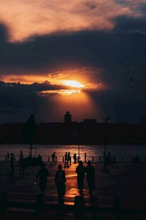 夕阳下海边的人群剪影