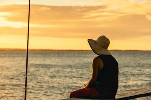 夕阳下海边独坐的女子