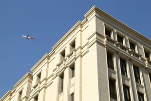 高楼旁蓝天中的飞机