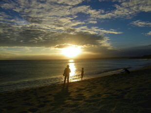 夕阳下海边漫步的温馨场景