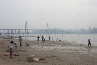 湛江江边沙滩上的休闲人群