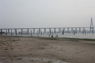 湛江海边长桥与沙滩上的行人