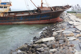 搁浅船只旁的碎石岸滩