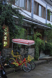 复古三轮车停靠在绿植建筑旁