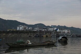 江边暮色中的船只与建筑