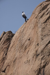 攀岩者立于陡峭岩壁之上