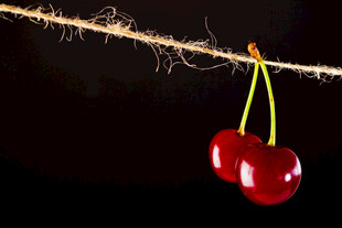 双颗红樱桃悬挂于绳上