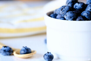 白杯盛着饱满新鲜蓝莓