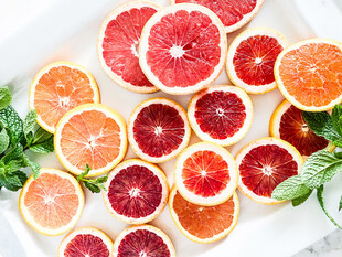 多彩切片柑橘与绿叶搭配