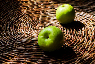 藤编上的两枚青苹果