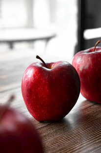 红苹果摆放在木质桌面上
