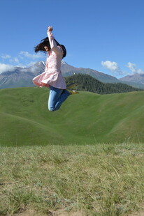 女孩在草原上欢快跳跃