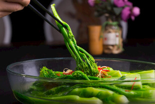 筷子夹起鲜嫩翠绿的蔬菜