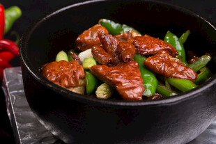 黑碗中的红烧牛肉与青椒