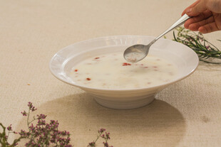 手持银勺舀起碗中美食