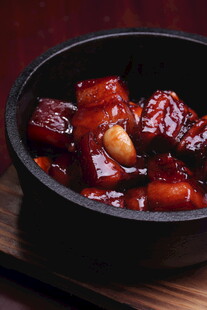 美味红烧肉盛于黑碗中
