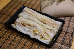美味肠粉置于黑色盘中