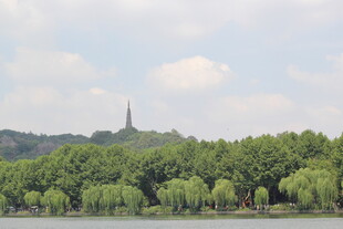 湖畔绿树环绕的远方尖塔