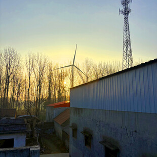 夕阳下的风车与通信塔