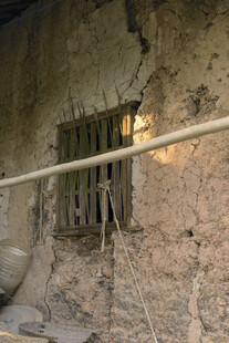 破旧土墙带铁栏的窗户